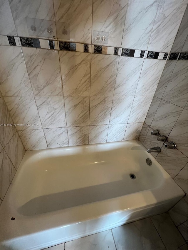 bathroom with a bathtub and tile walls