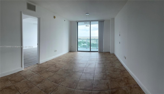 tiled empty room with a wall of windows