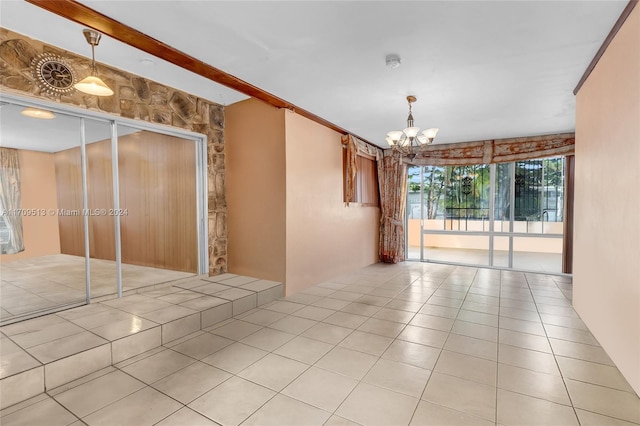 spare room with a chandelier and light tile patterned floors