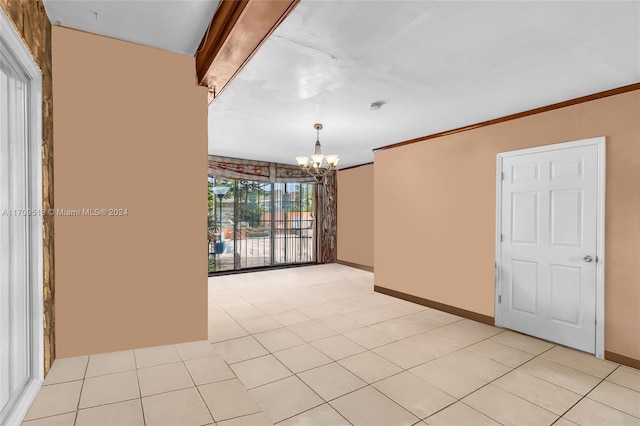 tiled empty room featuring crown molding and a chandelier