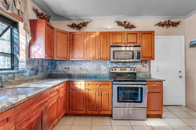 kitchen featuring tasteful backsplash, sink, light tile patterned flooring, and appliances with stainless steel finishes