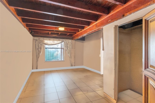 basement featuring wooden ceiling and light tile patterned flooring