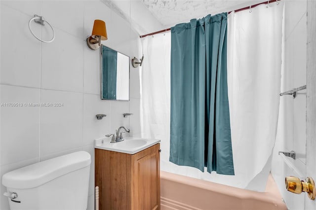 full bathroom with vanity, toilet, shower / bath combo with shower curtain, and tile walls