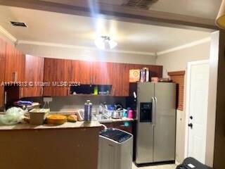 kitchen featuring stainless steel fridge with ice dispenser and ornamental molding