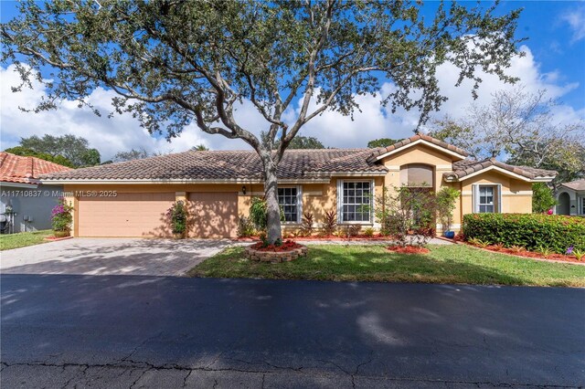 mediterranean / spanish-style home with a garage and a front yard