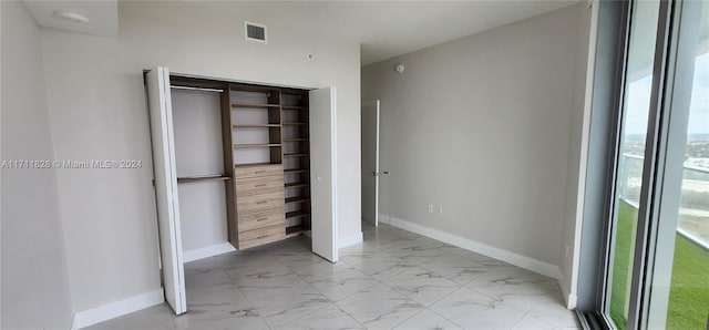 unfurnished bedroom featuring multiple windows and a closet