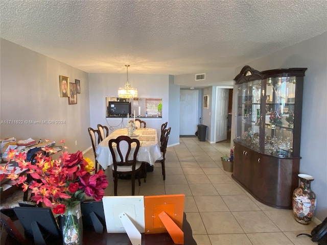 dining room featuring light tile patterned floors, a textured ceiling, and a chandelier