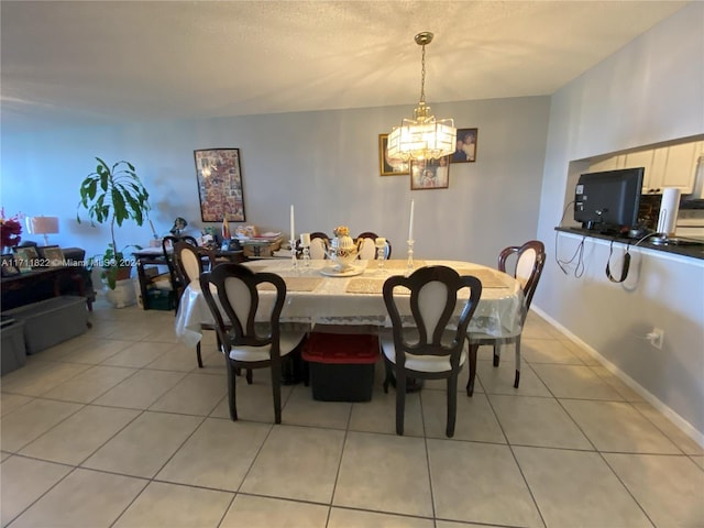 tiled dining room featuring an inviting chandelier