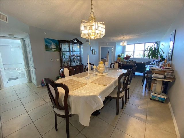 dining room with light tile patterned flooring, a textured ceiling, and an inviting chandelier