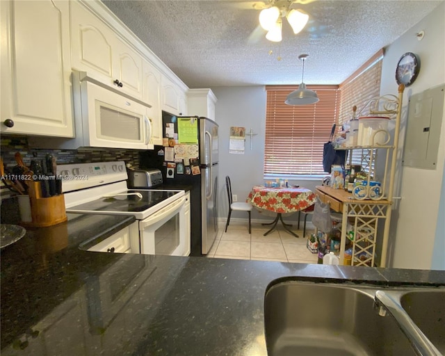 kitchen featuring a textured ceiling, white cabinets, and white appliances