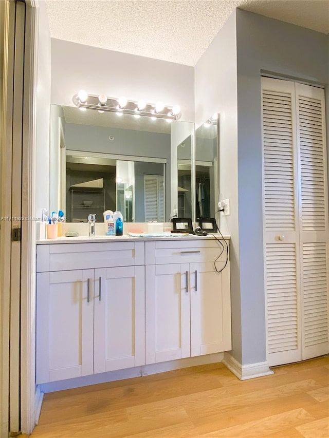 bathroom with vanity, hardwood / wood-style floors, and a textured ceiling