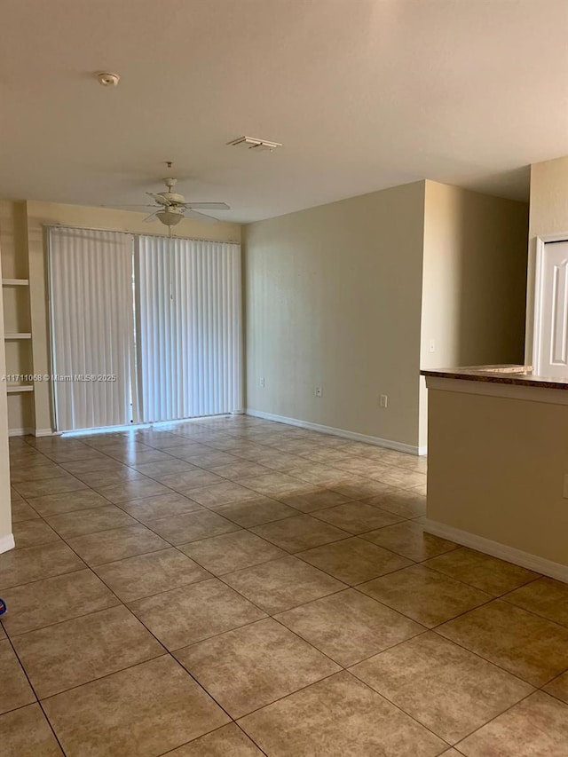 spare room featuring visible vents, ceiling fan, baseboards, and light tile patterned flooring