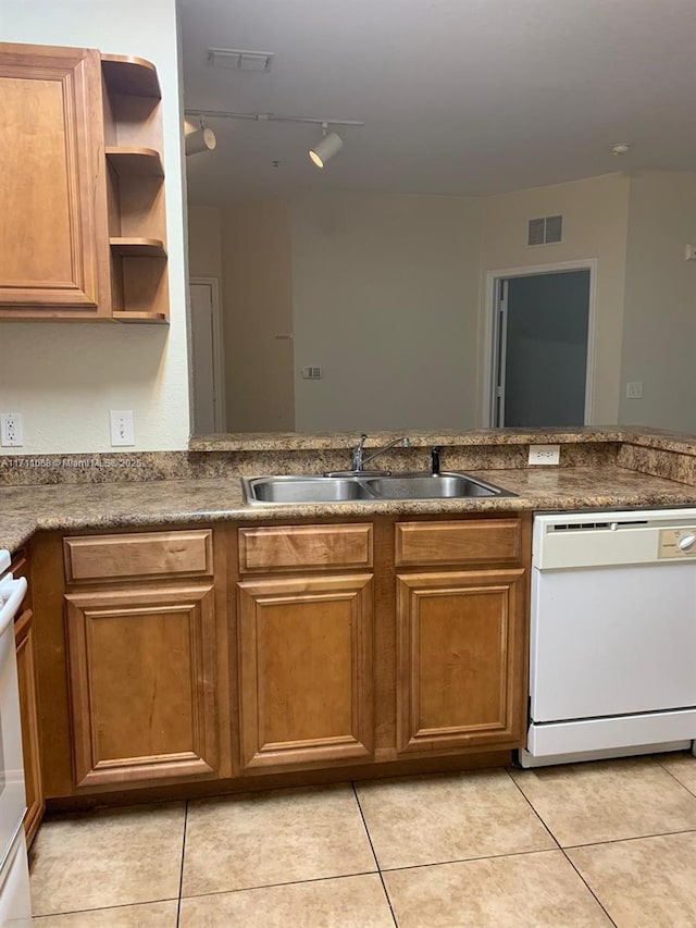 kitchen featuring dishwasher, a sink, visible vents, and brown cabinets