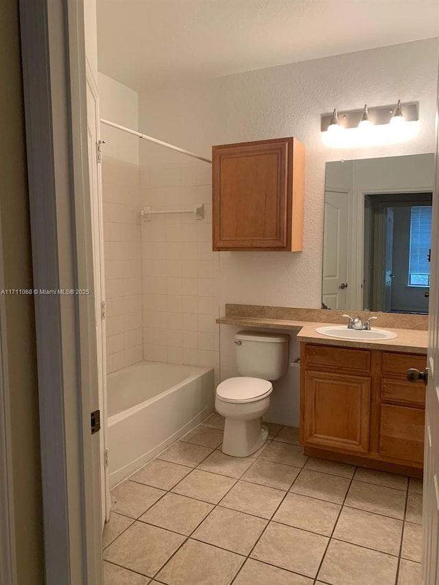 full bathroom with a textured wall, shower / tub combination, toilet, vanity, and tile patterned floors