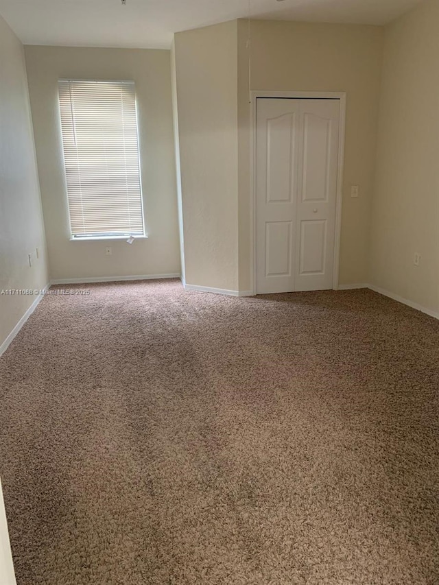 unfurnished bedroom with a closet, carpet, and baseboards