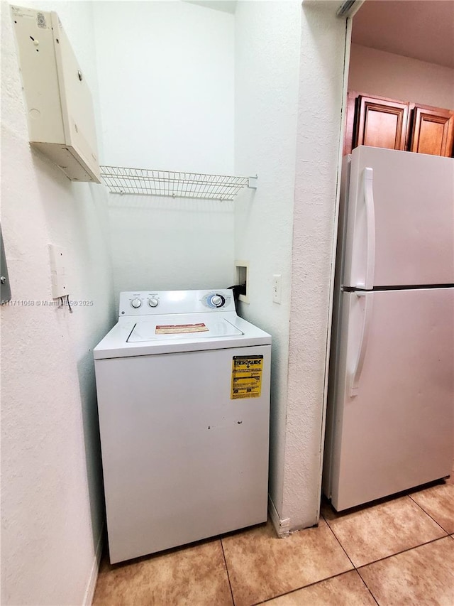 6169 Metrowest Blvd Unit 104, Orlando, FL 32835 - laundry room with washer / dryer, light tile patterned floors, and a textured wall