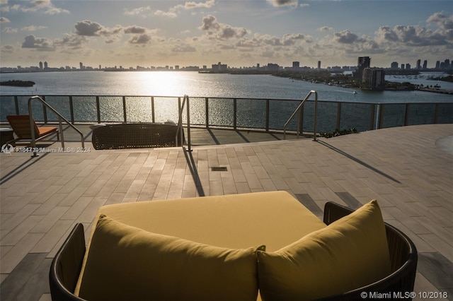 patio terrace at dusk with an outdoor living space and a water view