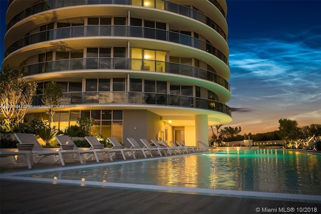 outdoor building at dusk featuring a community pool