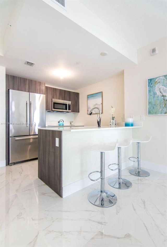 kitchen with a kitchen breakfast bar and stainless steel appliances