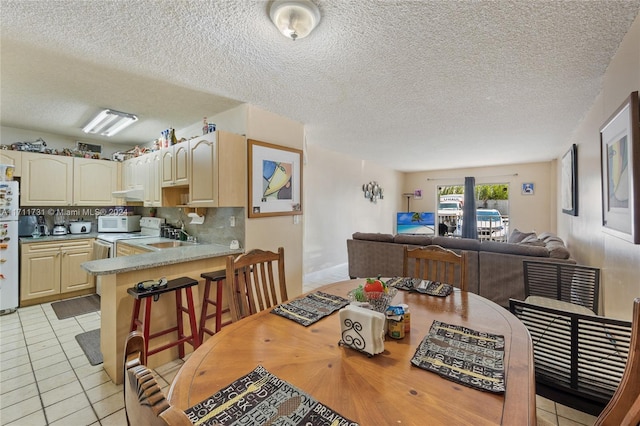 tiled dining space featuring a textured ceiling