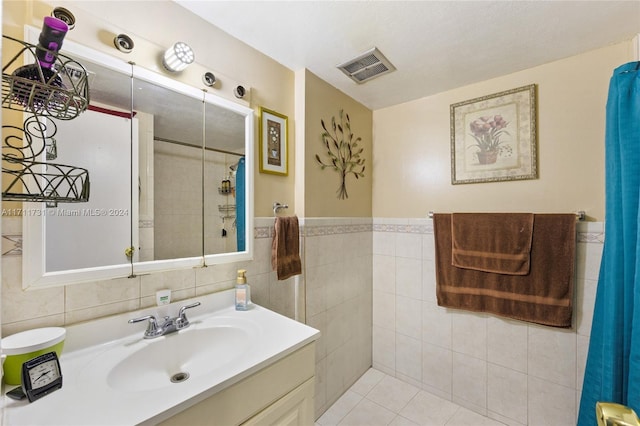 bathroom featuring tile patterned floors, vanity, tile walls, and walk in shower