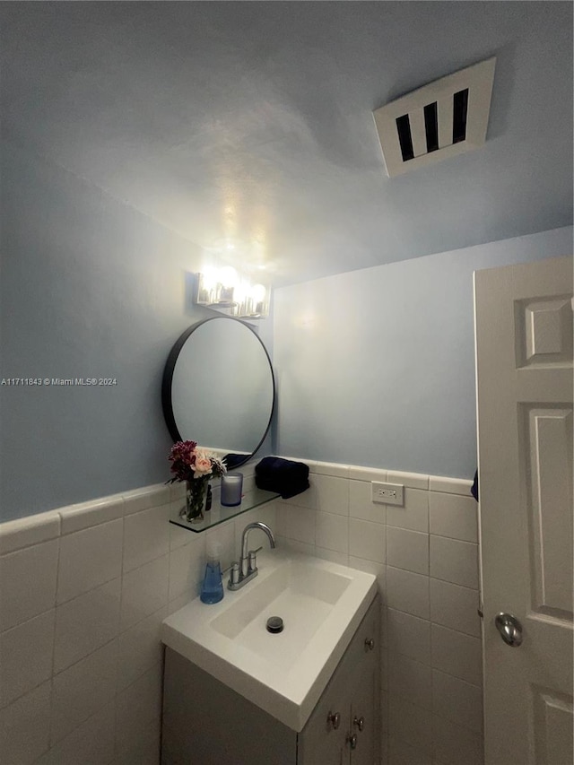 bathroom featuring vanity and tile walls