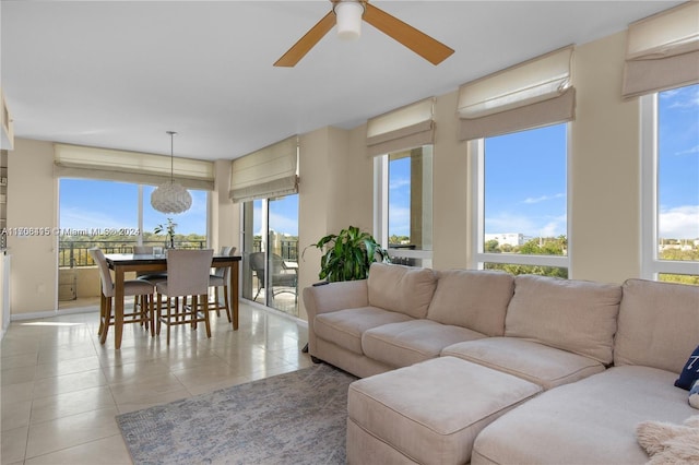 living room featuring light tile patterned floors, ceiling fan, and a healthy amount of sunlight