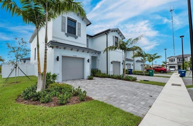 mediterranean / spanish-style house featuring a garage and a front lawn