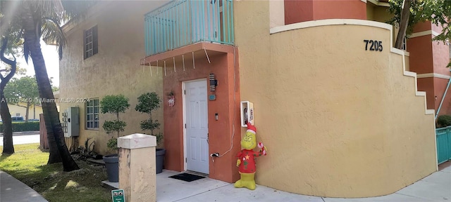 view of exterior entry with a balcony