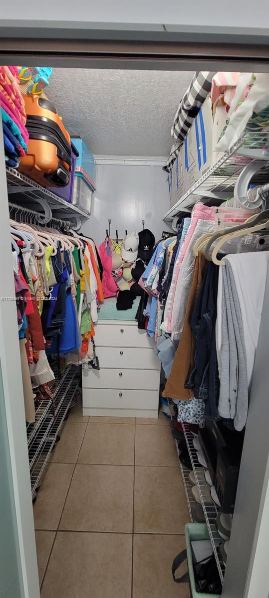 walk in closet with light tile patterned floors