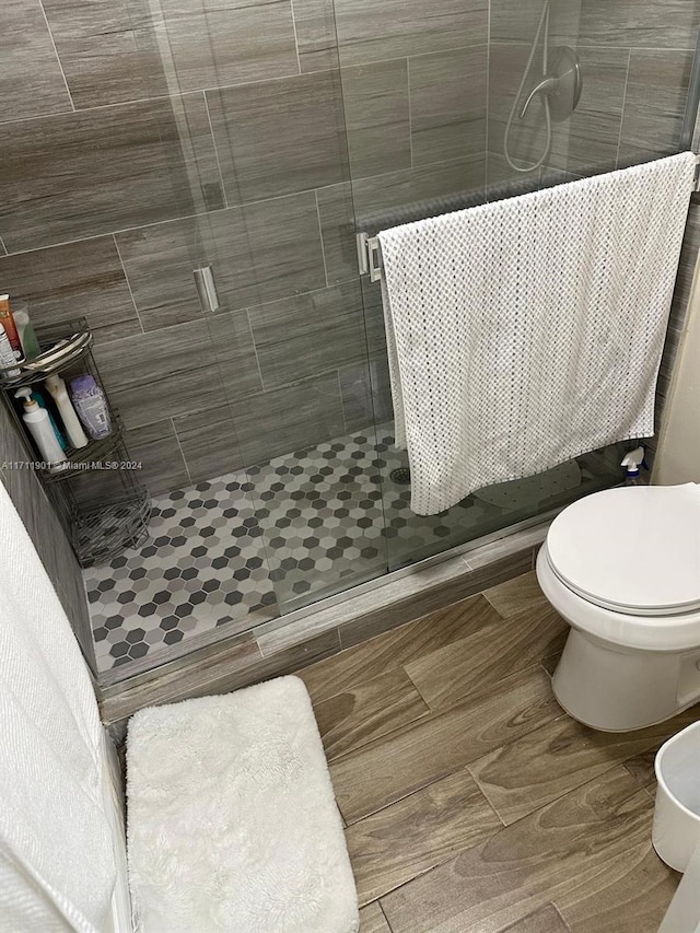 bathroom featuring toilet, walk in shower, and tile walls