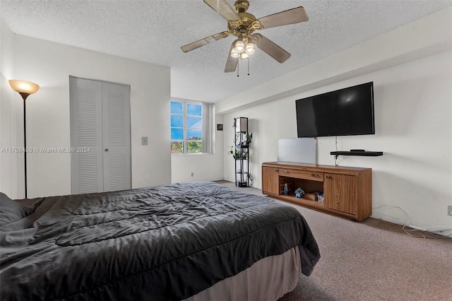 carpeted bedroom featuring ceiling fan, a textured ceiling, and a closet