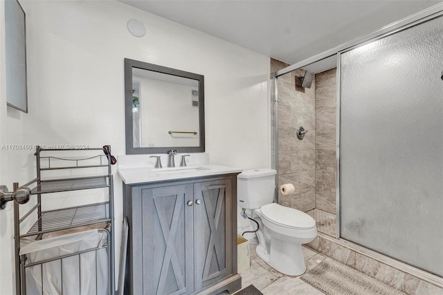 bathroom with vanity, toilet, and a shower with shower door