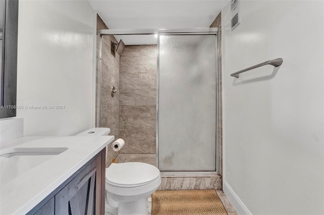 bathroom with tile patterned floors, vanity, toilet, and a shower with door