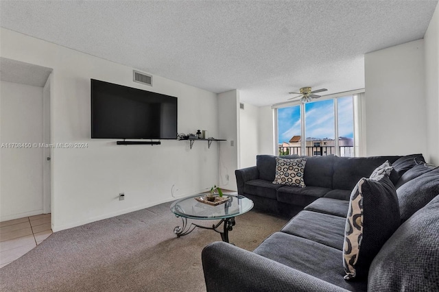 carpeted living room featuring ceiling fan and a textured ceiling