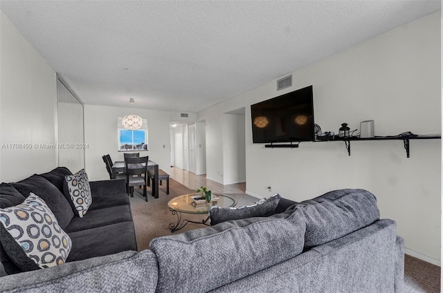 carpeted living room featuring a textured ceiling