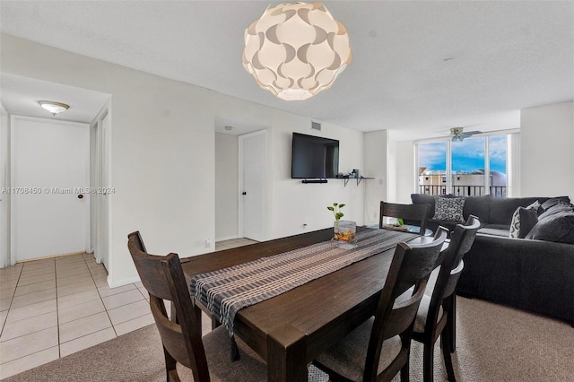 dining area with tile patterned floors, ceiling fan, and a textured ceiling