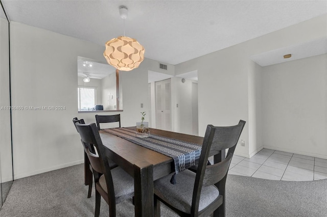 dining area with light tile patterned floors and a textured ceiling