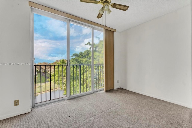 carpeted spare room featuring ceiling fan and a textured ceiling