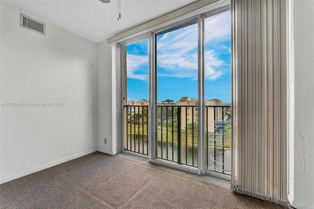 empty room with carpet, a textured ceiling, and ceiling fan