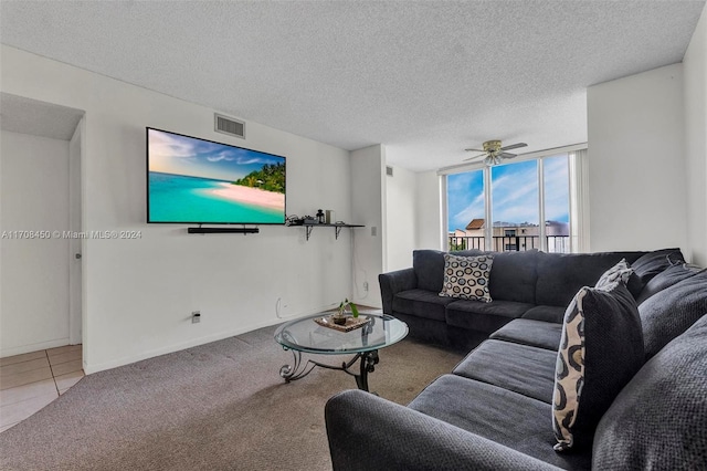 living room with carpet flooring, a textured ceiling, and ceiling fan