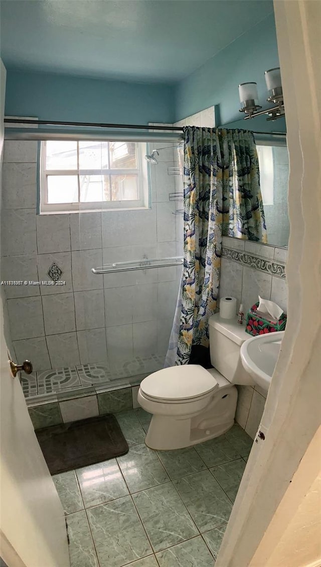 bathroom featuring tile patterned floors, curtained shower, tile walls, and toilet