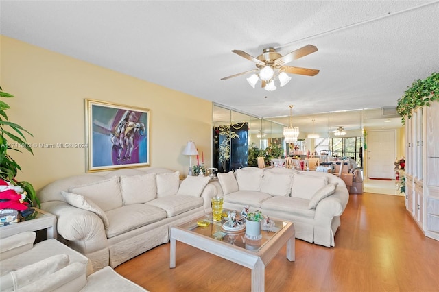 living room with wood-type flooring, a textured ceiling, and ceiling fan