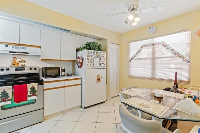 kitchen with ventilation hood, ceiling fan, white refrigerator, white cabinets, and stainless steel electric range oven