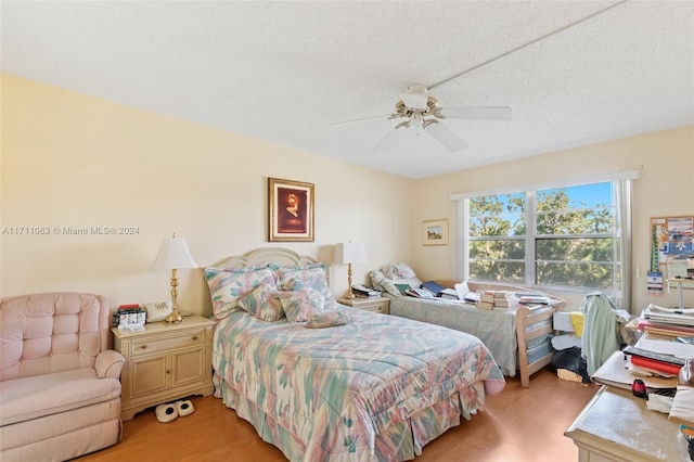 bedroom featuring ceiling fan, a textured ceiling, and light wood-type flooring