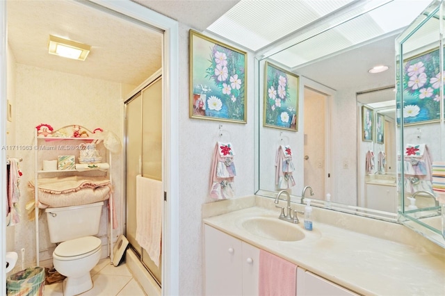 bathroom featuring tile patterned floors, toilet, vanity, and walk in shower