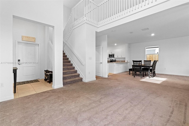 living room with a high ceiling and light colored carpet