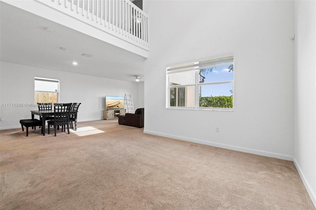 interior space featuring light colored carpet and a high ceiling