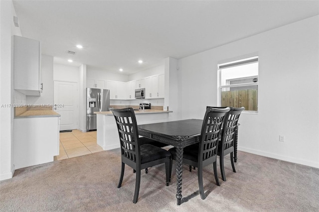 dining space featuring light colored carpet