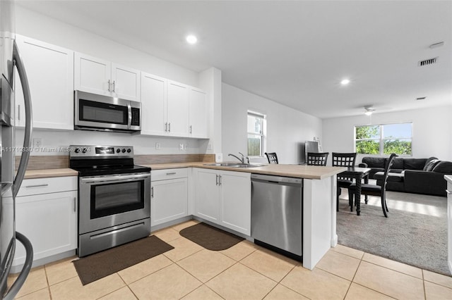 kitchen with white cabinetry, appliances with stainless steel finishes, kitchen peninsula, and sink